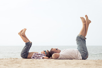 Image showing Father and son playing on the beach at the day time.