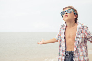 Image showing One happy little boy playing on the beach at the day time.