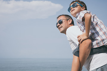 Image showing Father and son playing on the beach at the day time.