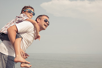 Image showing Father and son playing on the beach at the day time.