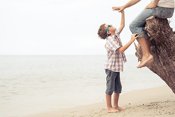 Image showing Father and son playing on the beach at the day time.