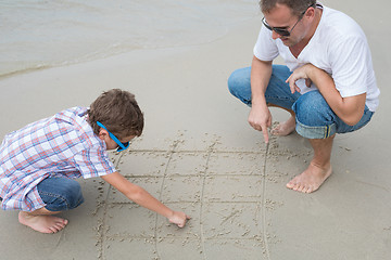 Image showing Father and son playing on the beach at the day time.