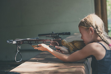 Image showing girl shoots a rifle in the dash