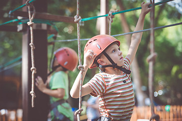 Image showing little boy make climbing in the adventure park.