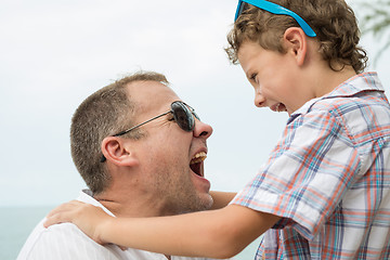 Image showing Father and son playing on the beach at the day time.