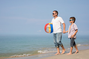 Image showing Father and son playing on the beach at the day time.