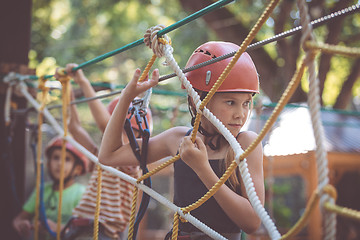 Image showing little brother and sister make climbing in the adventure park.