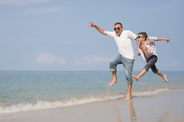 Image showing Father and son playing on the beach at the day time.