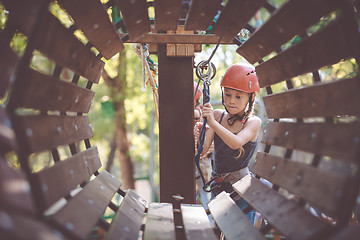 Image showing little brother and sister make climbing in the adventure park.