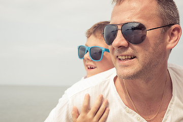 Image showing Father and son playing on the beach at the day time.