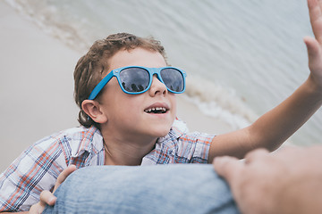 Image showing Father and son playing on the beach at the day time.