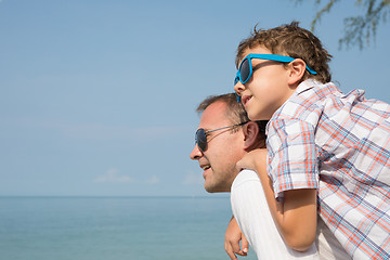 Image showing Father and son playing on the beach at the day time.