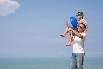 Image showing Father and son playing on the beach at the day time.