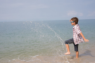 Image showing One happy little boy playing on the beach at the day time.