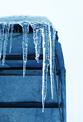 Image showing Big icicles hanging from the roof at the corner of the building