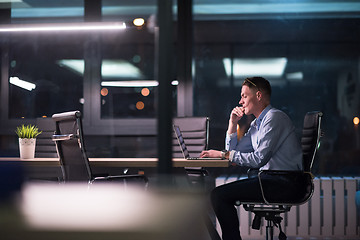 Image showing man working on laptop in dark office