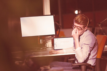 Image showing man working on computer in dark office