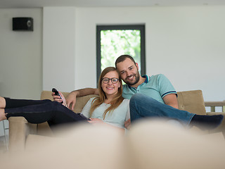 Image showing Young couple on the sofa watching television