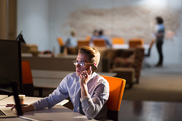 Image showing man using mobile phone in dark office