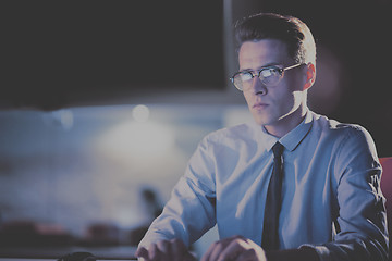 Image showing man working on computer in dark office