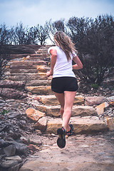 Image showing Fit active woman running up stairs in outdoor landscape