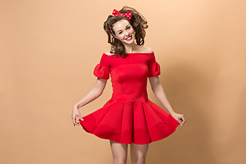 Image showing Beautiful young woman with pinup make-up and hairstyle. Studio shot on pastel background