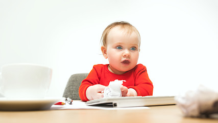 Image showing Happy child baby girl toddler sitting with keyboard of computer isolated on a white background