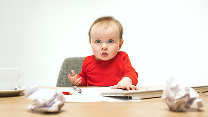 Image showing Happy child baby girl toddler sitting with keyboard of computer isolated on a white background