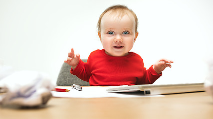 Image showing Happy child baby girl toddler sitting with keyboard of computer isolated on a white background