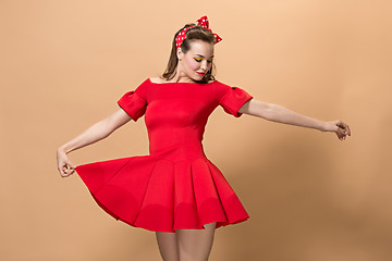 Image showing Beautiful young woman with pinup make-up and hairstyle. Studio shot on pastel background