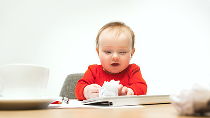 Image showing Happy child baby girl toddler sitting with keyboard of computer isolated on a white background