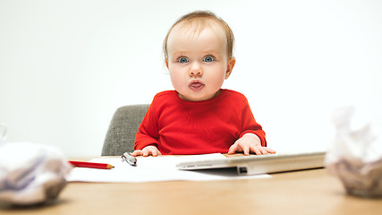 Image showing Happy child baby girl toddler sitting with keyboard of computer isolated on a white background