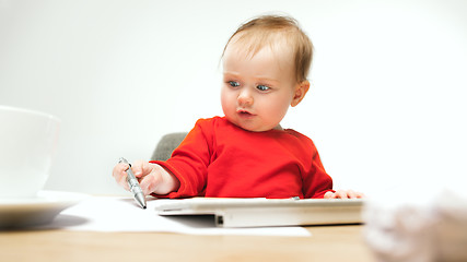 Image showing Happy child baby girl toddler sitting with keyboard of computer isolated on a white background