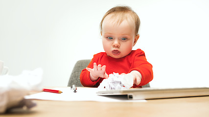 Image showing Happy child baby girl toddler sitting with keyboard of computer isolated on a white background