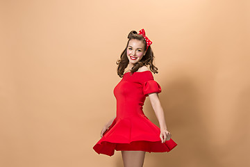 Image showing Beautiful young woman with pinup make-up and hairstyle. Studio shot on pastel background