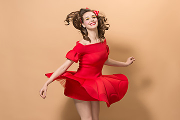 Image showing Beautiful young woman with pinup make-up and hairstyle. Studio shot on pastel background