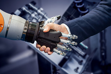 Image showing Hand of a businessman shaking hands with a Android robot.