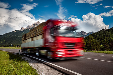 Image showing Timber truck rushes down the highway in the background the Alps.
