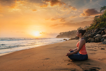 Image showing Woman doing yoga at beach - Padmasana lotus pose