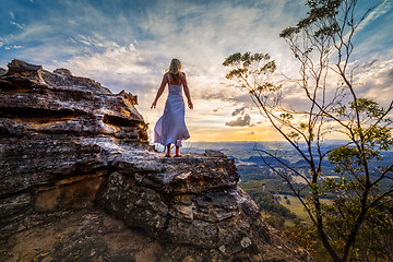 Image showing Standing on a rock  with dress blowing in the wind she dreams