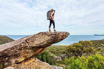 Image showing Hiker on rock cliff precipice with views