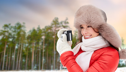 Image showing happy woman with film camera over winter forest