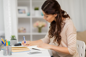 Image showing female student with book learning at home