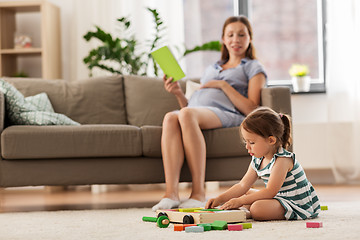 Image showing happy baby girl playing with toy blocks at home