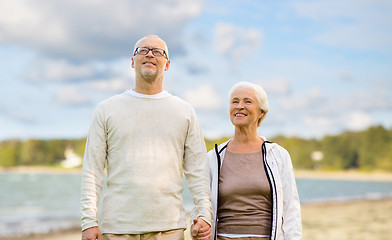 Image showing happy senior couple over beach background