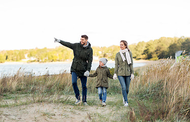 Image showing happy family walking along autumn beach