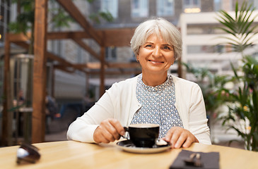 Image showing senior woman with coffee at street cafe