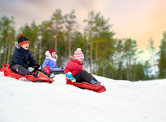 Image showing kids sliding on sleds down snow hill in winter