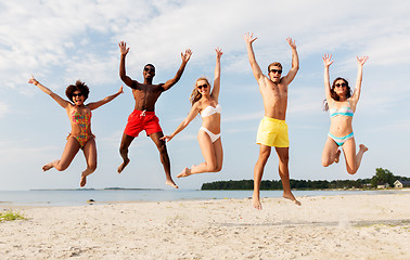 Image showing happy friends jumping on summer beach