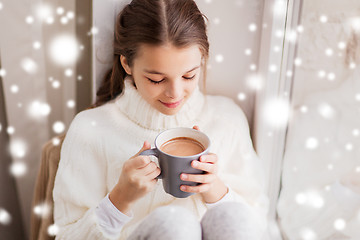 Image showing girl in winter sweater with cacao mug at window